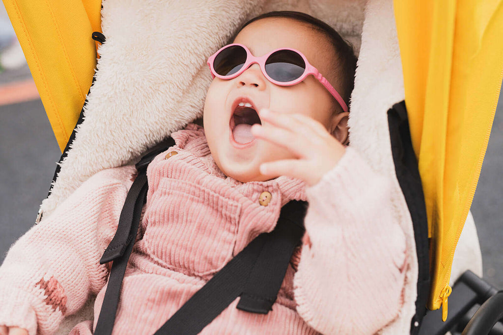 baby opening mouth and looking up with ourson sunglasses