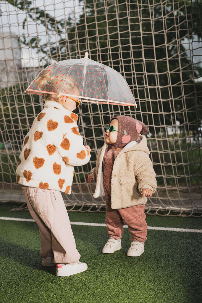 girl and baby under an umbrella with sunglasses